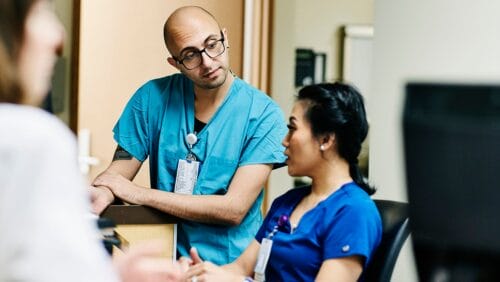 Nurses stand together at the nursing station