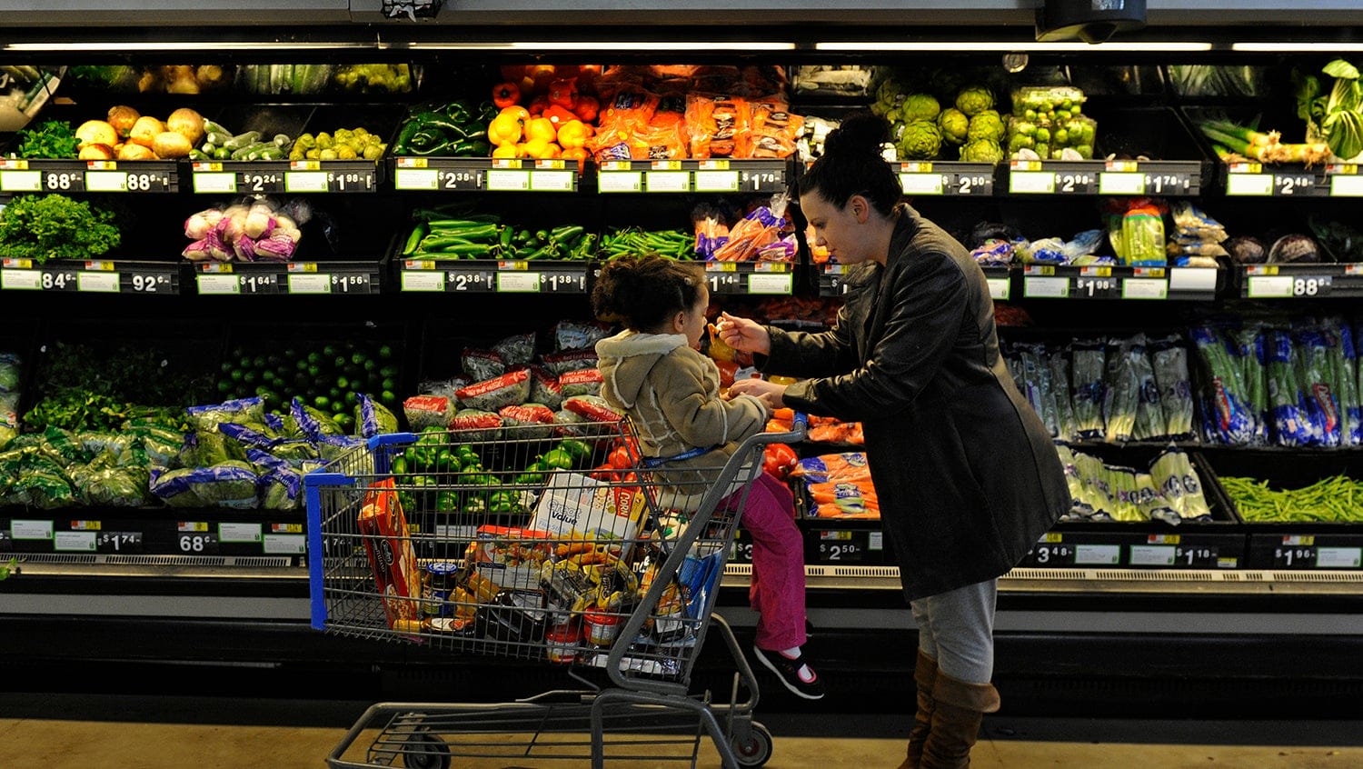 Parent talking to child seated in shopping cart