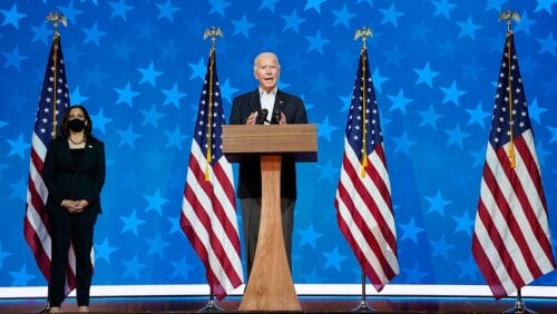 Biden and Harris stand on stage flanked by American flags