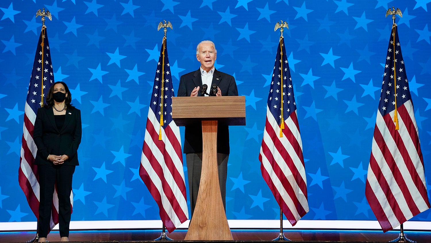 Biden and Harris stand on stage flanked by American flags