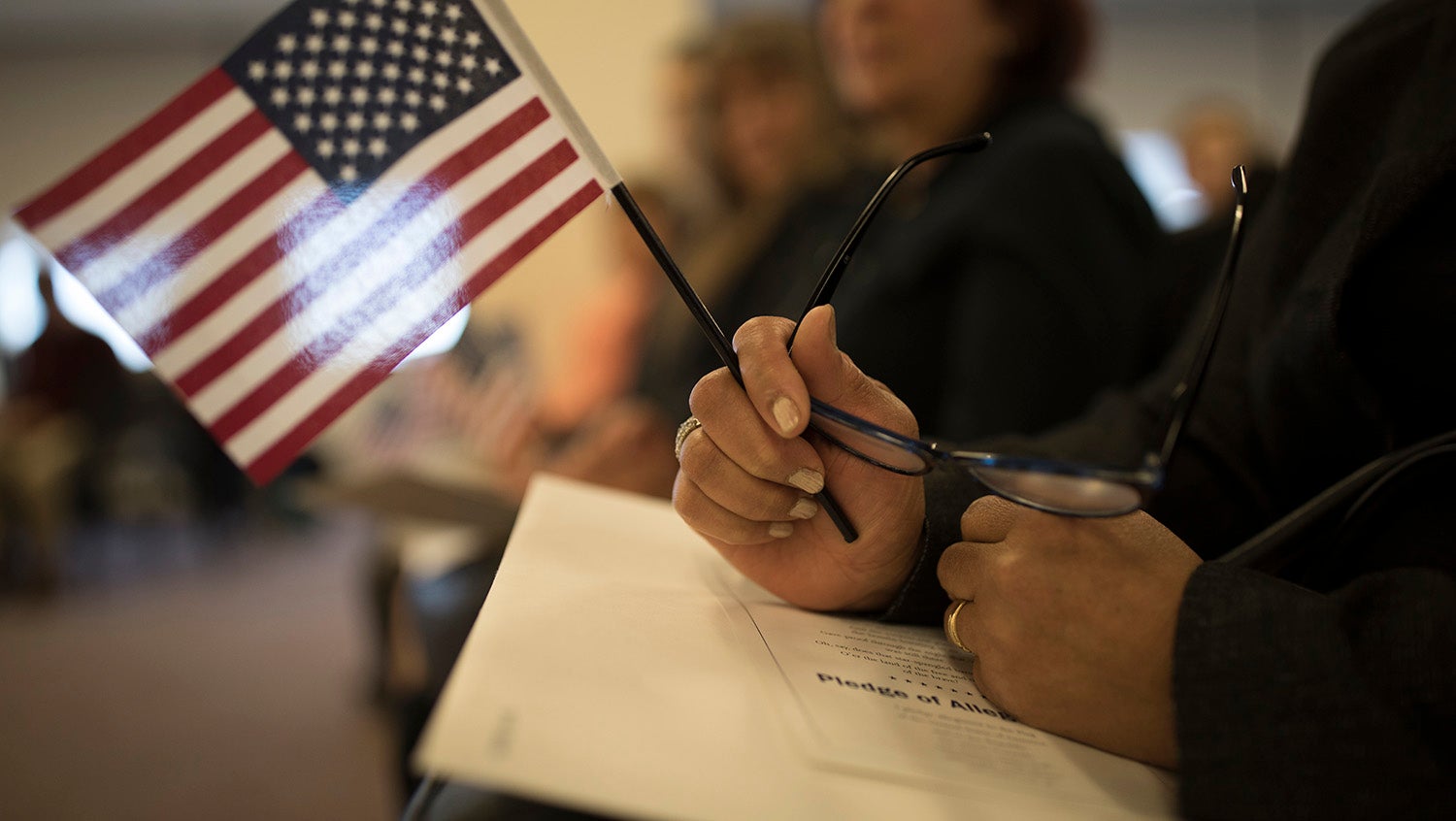 Woman holds American flag during a naturalization ceremony