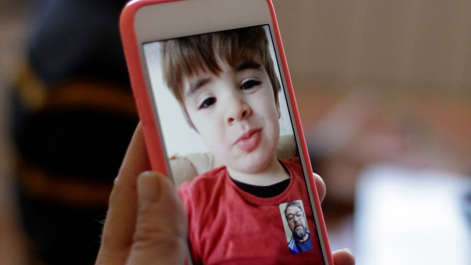 Young child appears on phone's screen in video chat