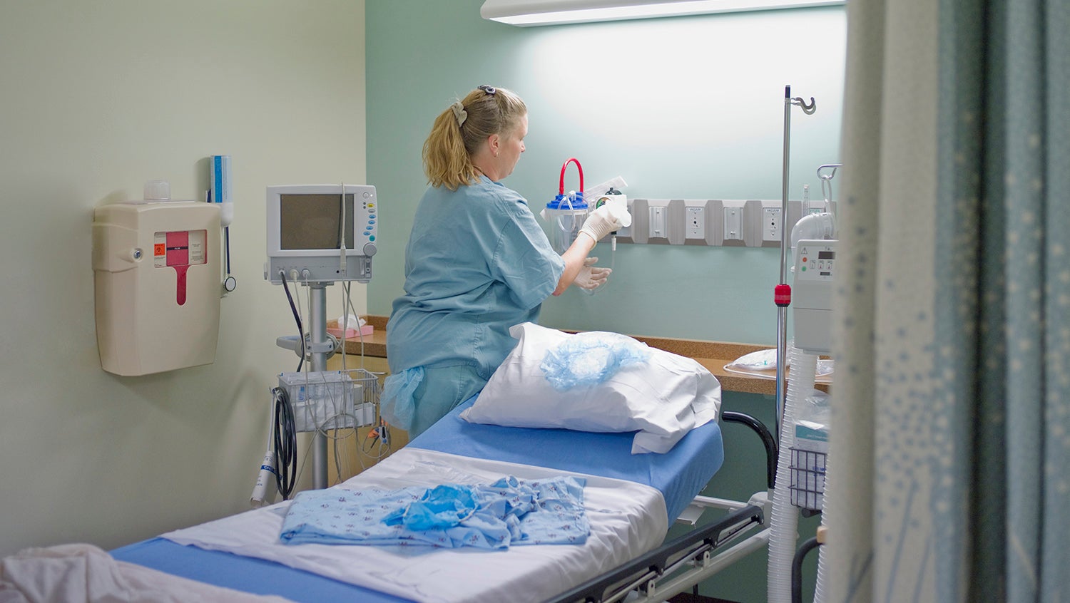case management nurse prepares an empty hospital bed after patient discharge