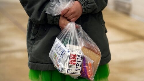 Young girl holding a bagged lunch