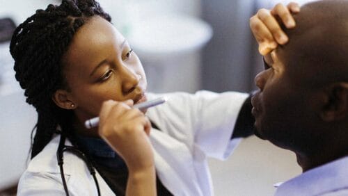 doctor looking at pupil size in patient