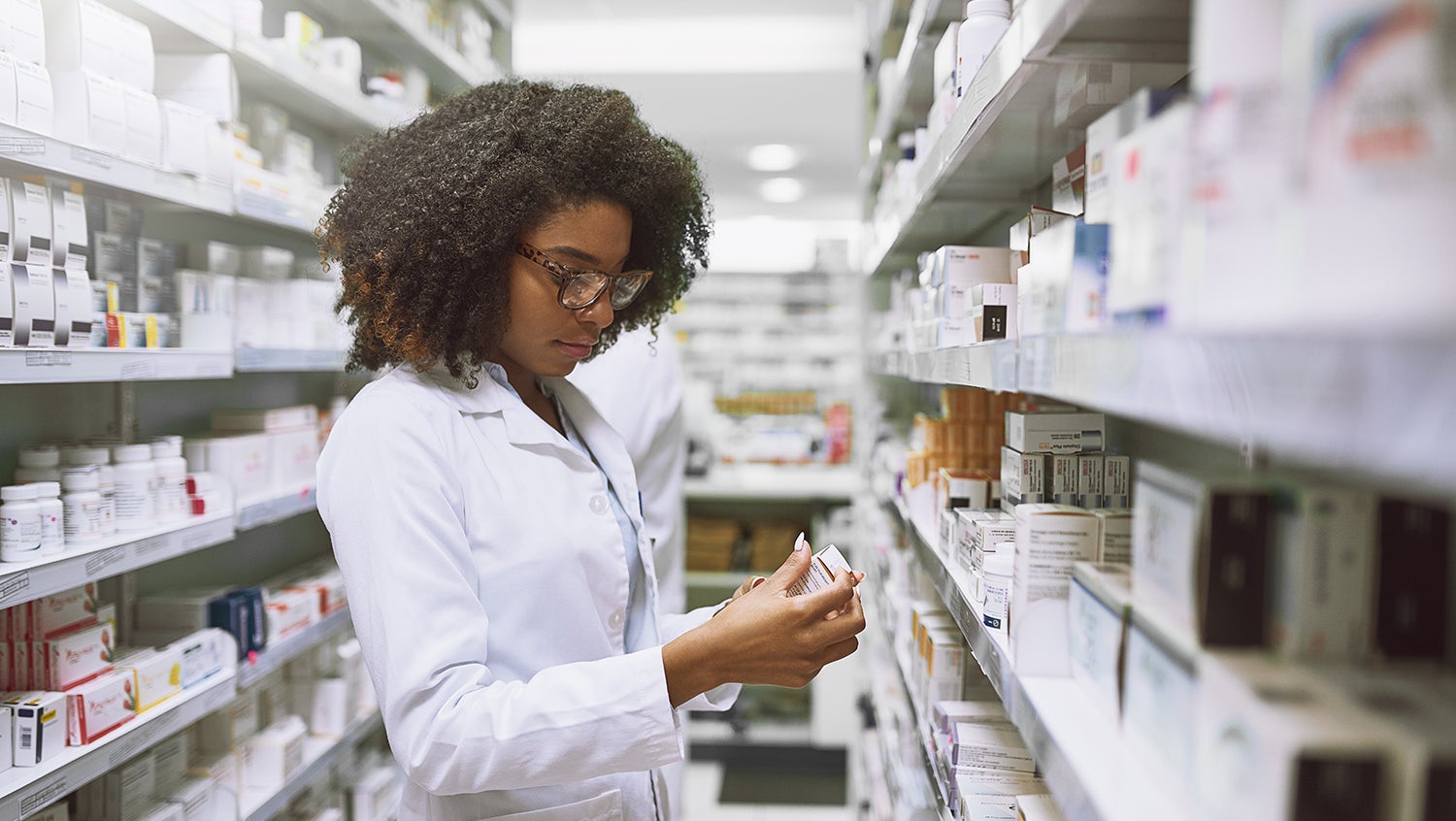 Pharmacist examines prescription medicine bottle
