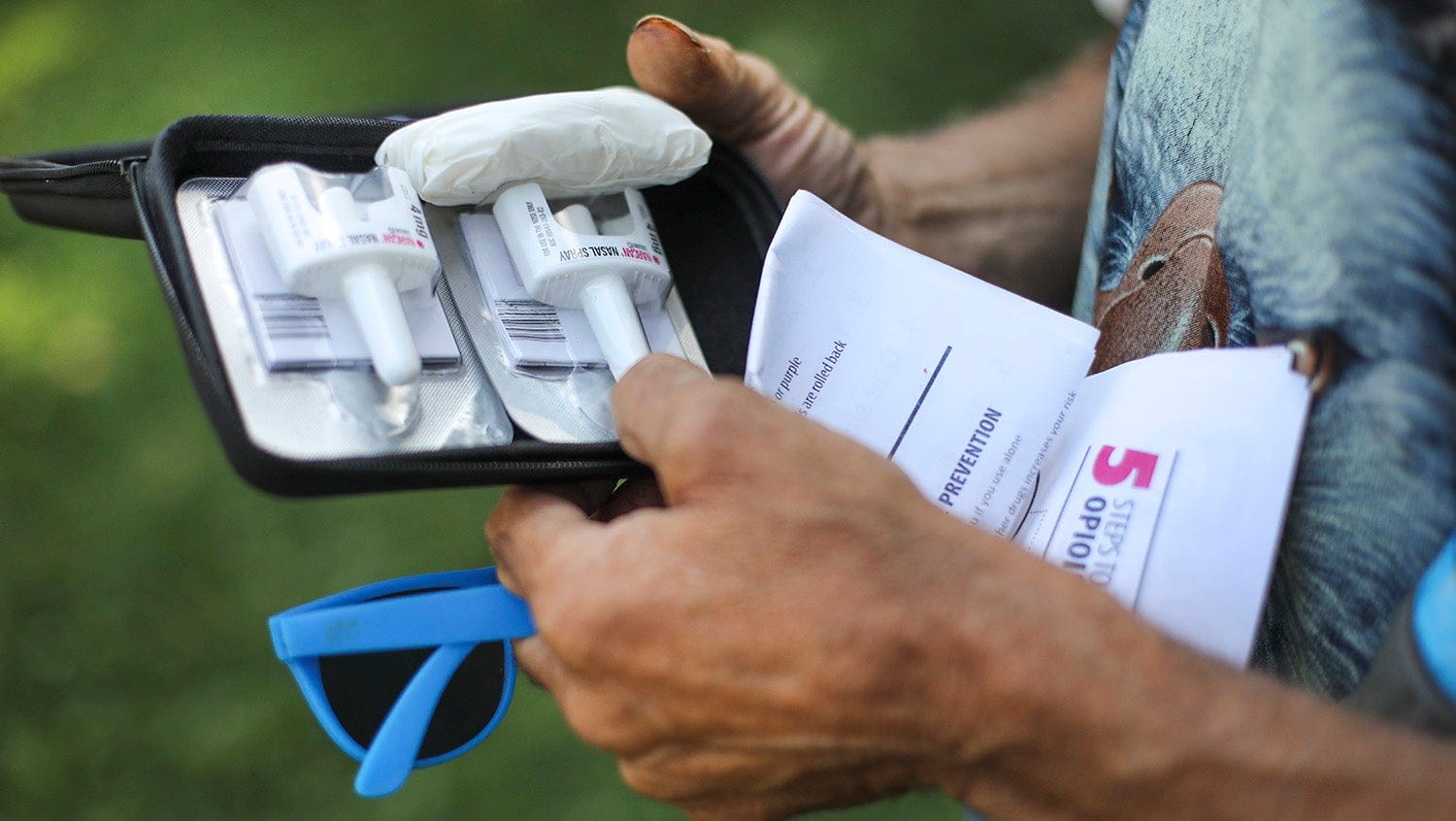 person holding opioid overdose kit with nasal spray narcan naloxone