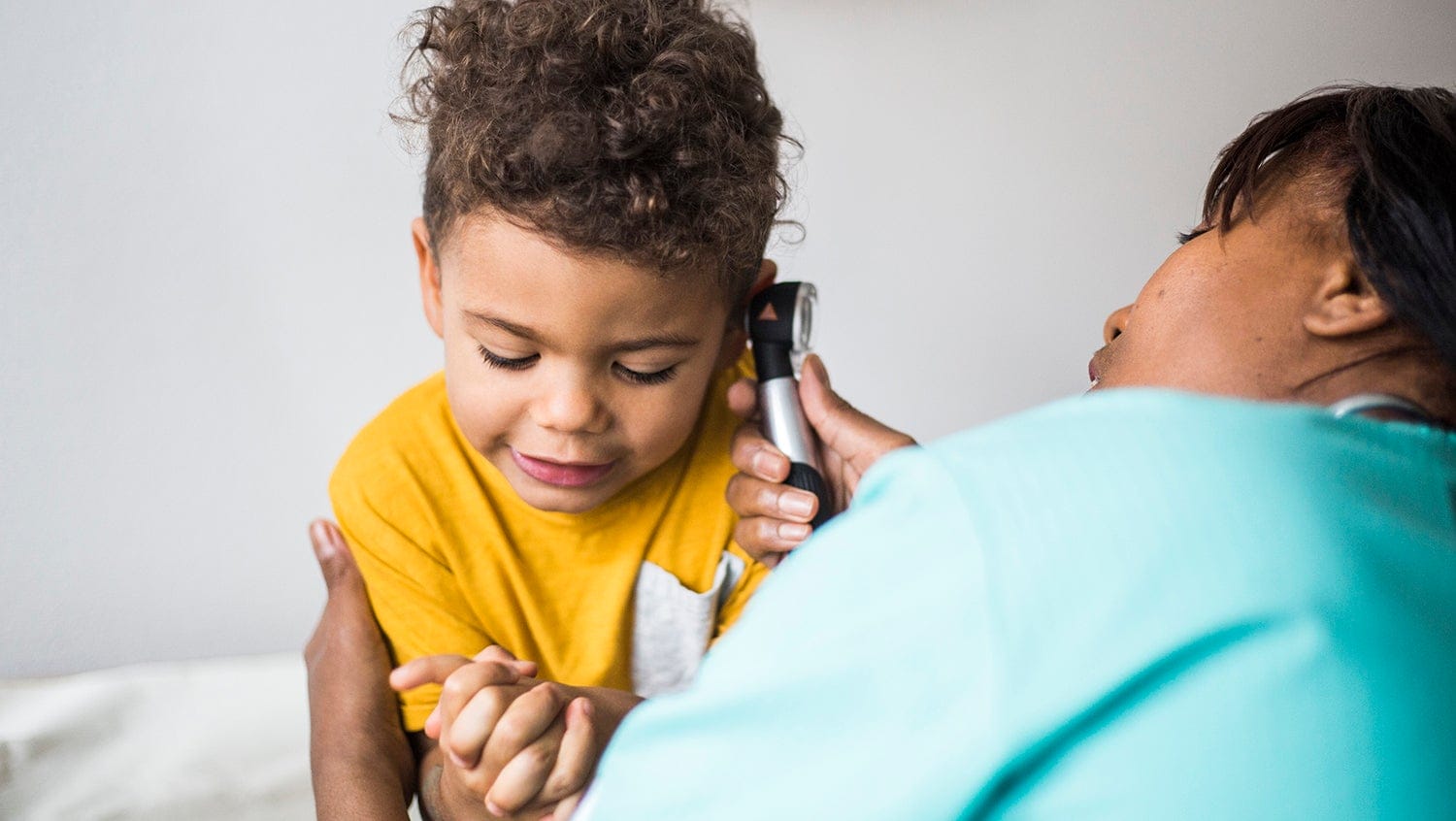 a ear nose and throat doctor checks a child's ear