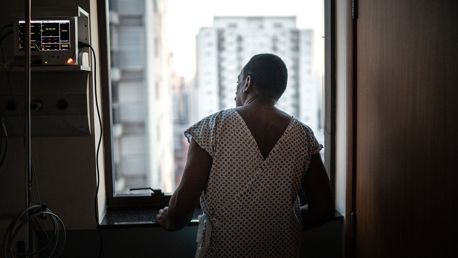 Rear view of a patient at the hospital looking through window