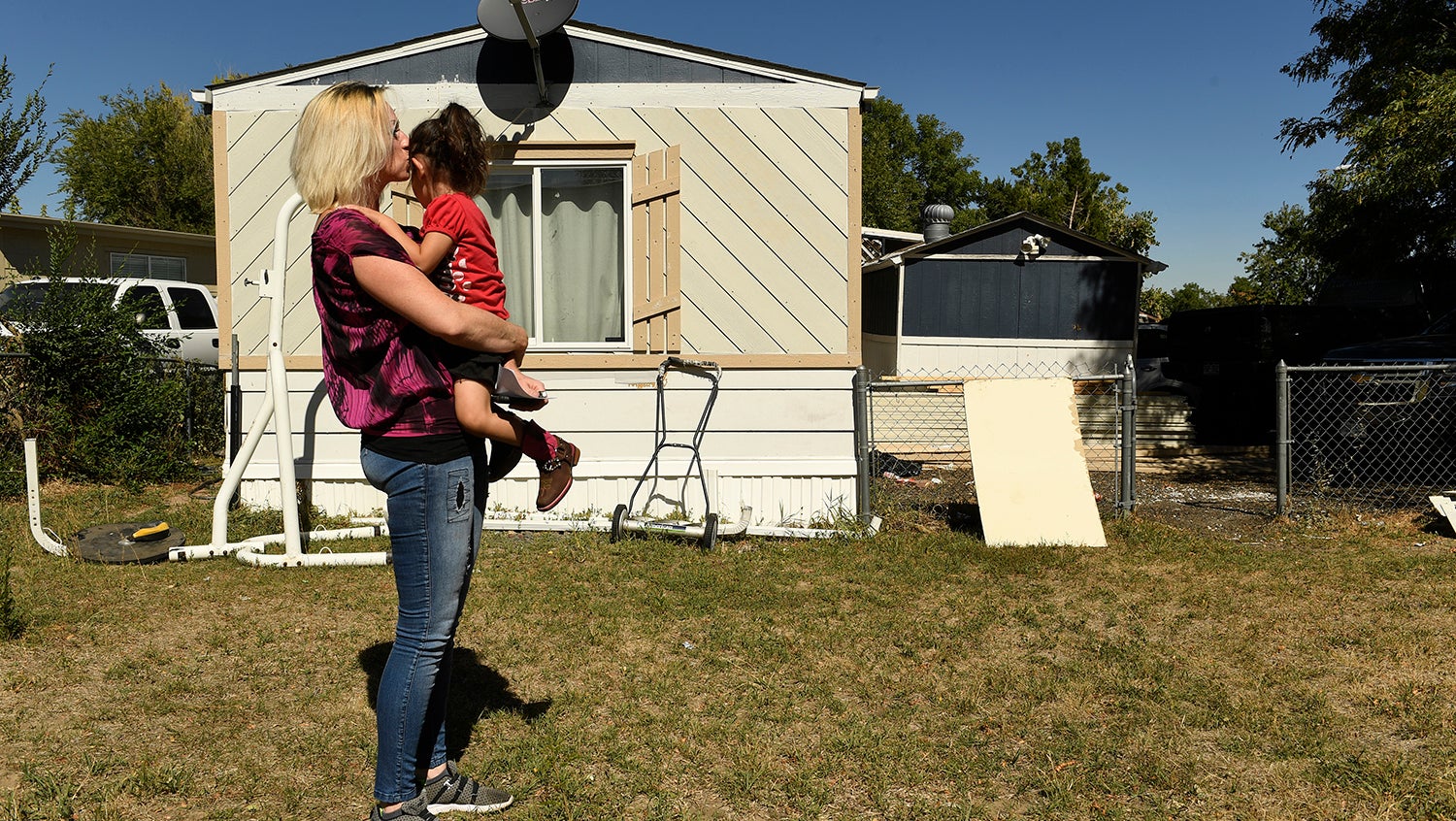 mother and daughter facing potential eviction look toward their mobile home