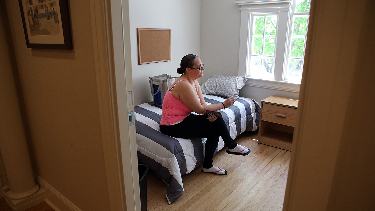 Woman sits in room at addiction treatment program for women 