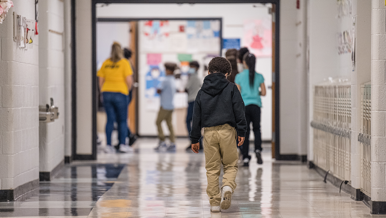 A young boy walks down a hallway at Carter Traditional Elementary School