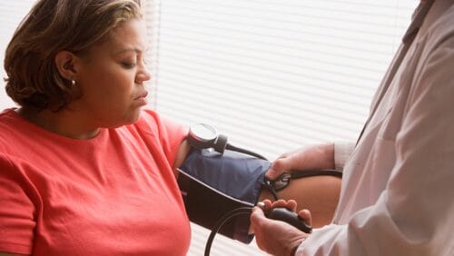 Doctor checks woman's blood pressure