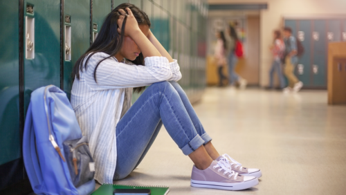 Child sits in hallway at school