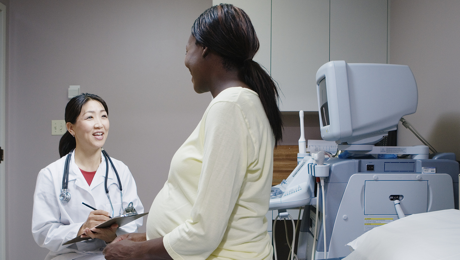 Physician talking with pregnant patient 