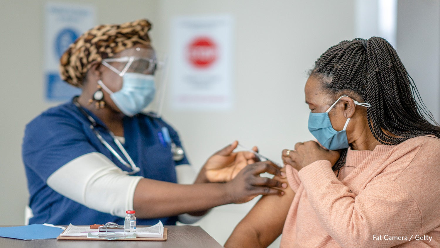 Woman receiving vaccine from nurse
