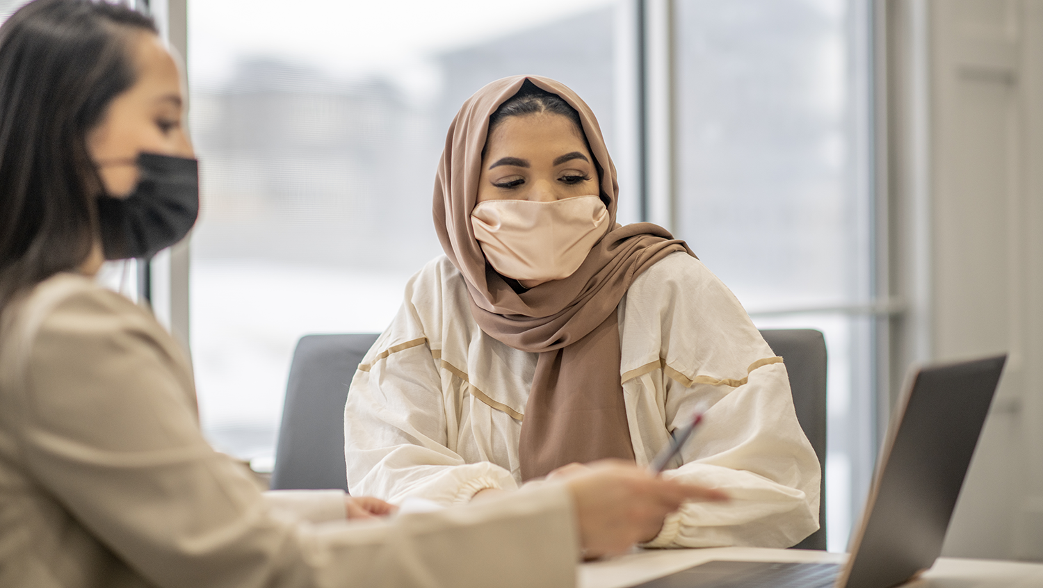 A Muslim woman is sitting at her doctor's office during an appointment