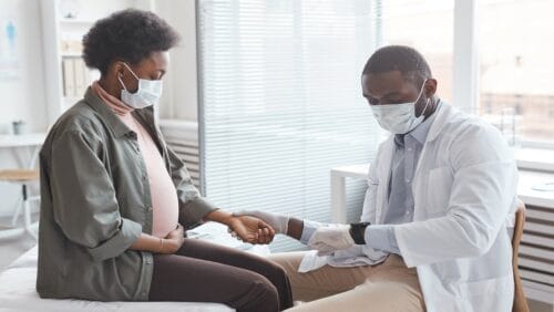 Doctor checks pregnant woman's pulse