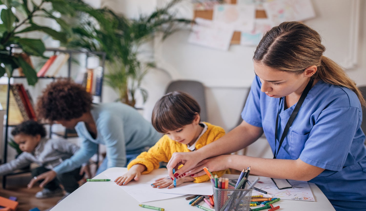 Nurse assisting child with coloring