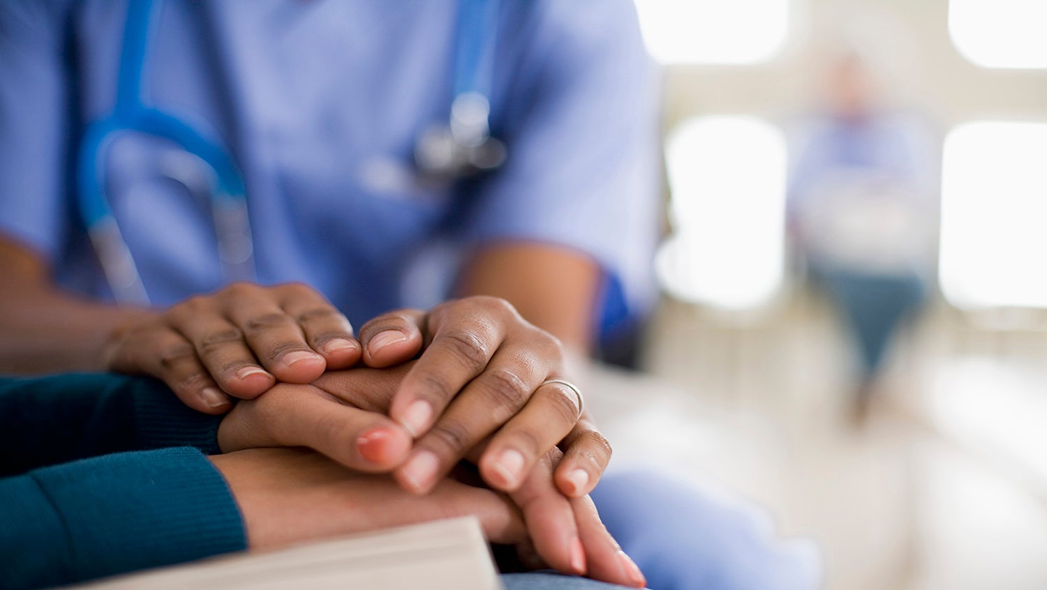 Doctor showing support for patient by touching hand