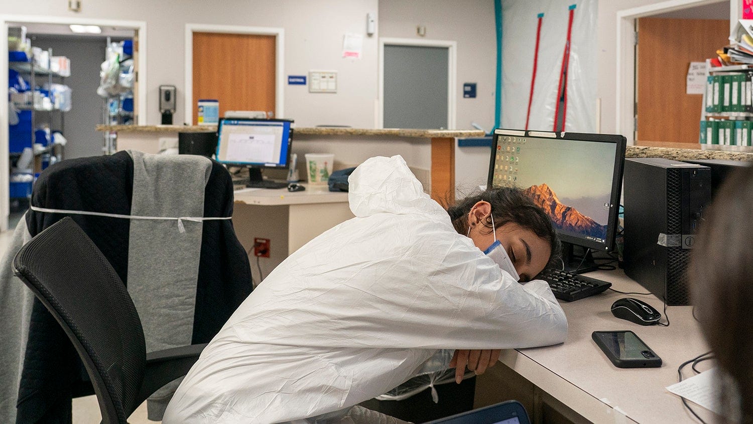 medical resident falls asleep at nurses station wearing PPE