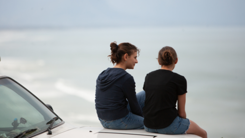 The backs of two girls sitting side by side