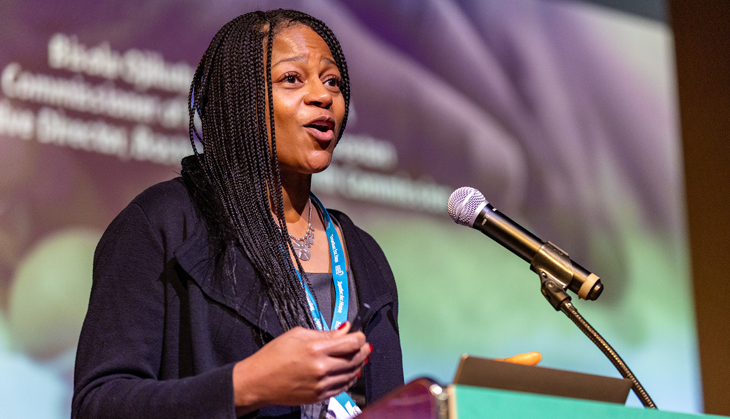 Bisola Ojikutu, a black woman speaking at a podium at the together for hope addiction conference in boston