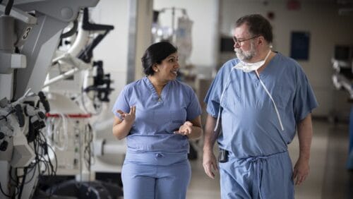 doctors on boston medical center's skull base surgery team wearing scrubs and walking down a hallway