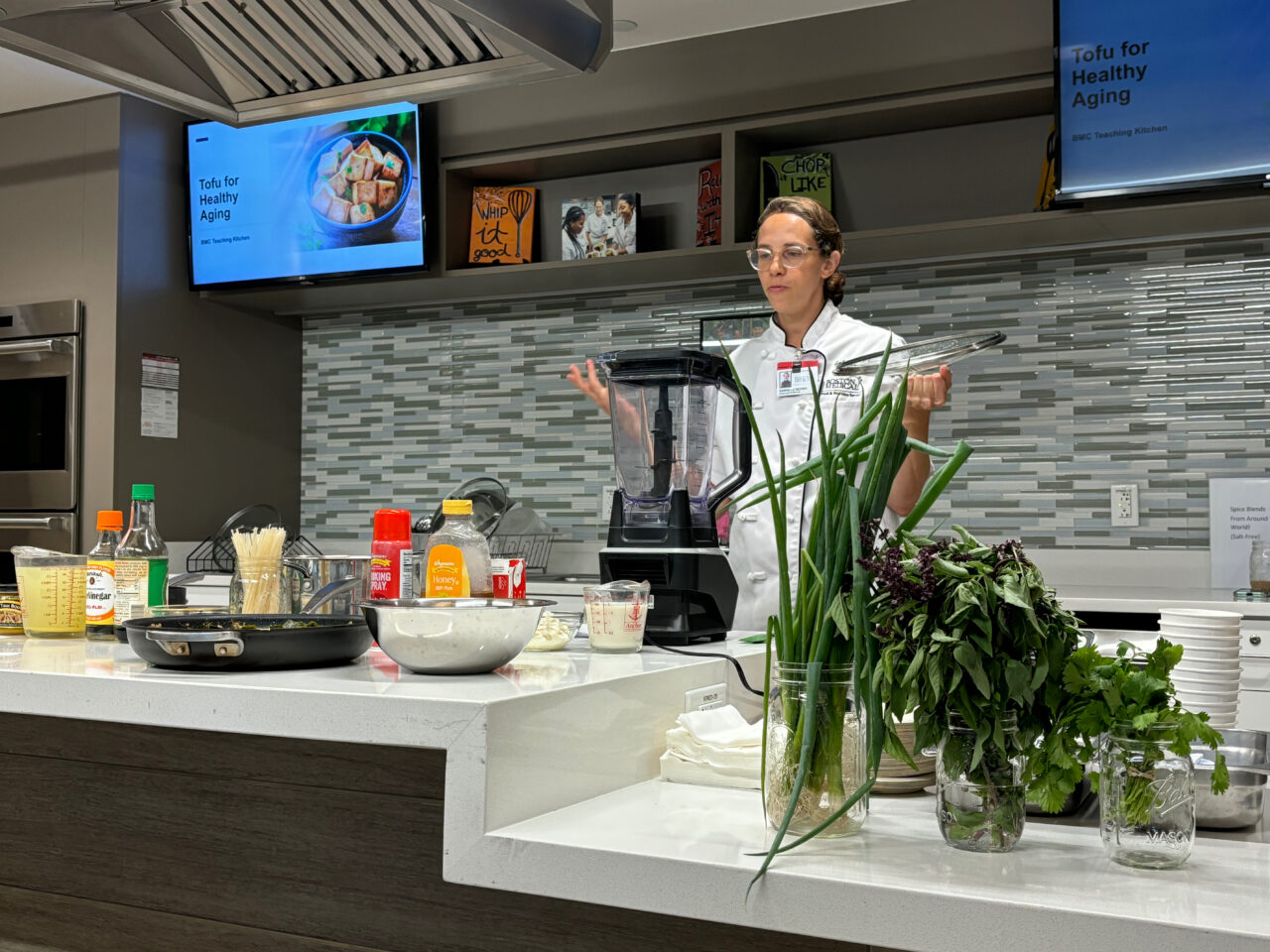 gaby simmons at boston medical center's teaching kitchen talking behind a counter about the benefits of tofu for the Geriatrics program.