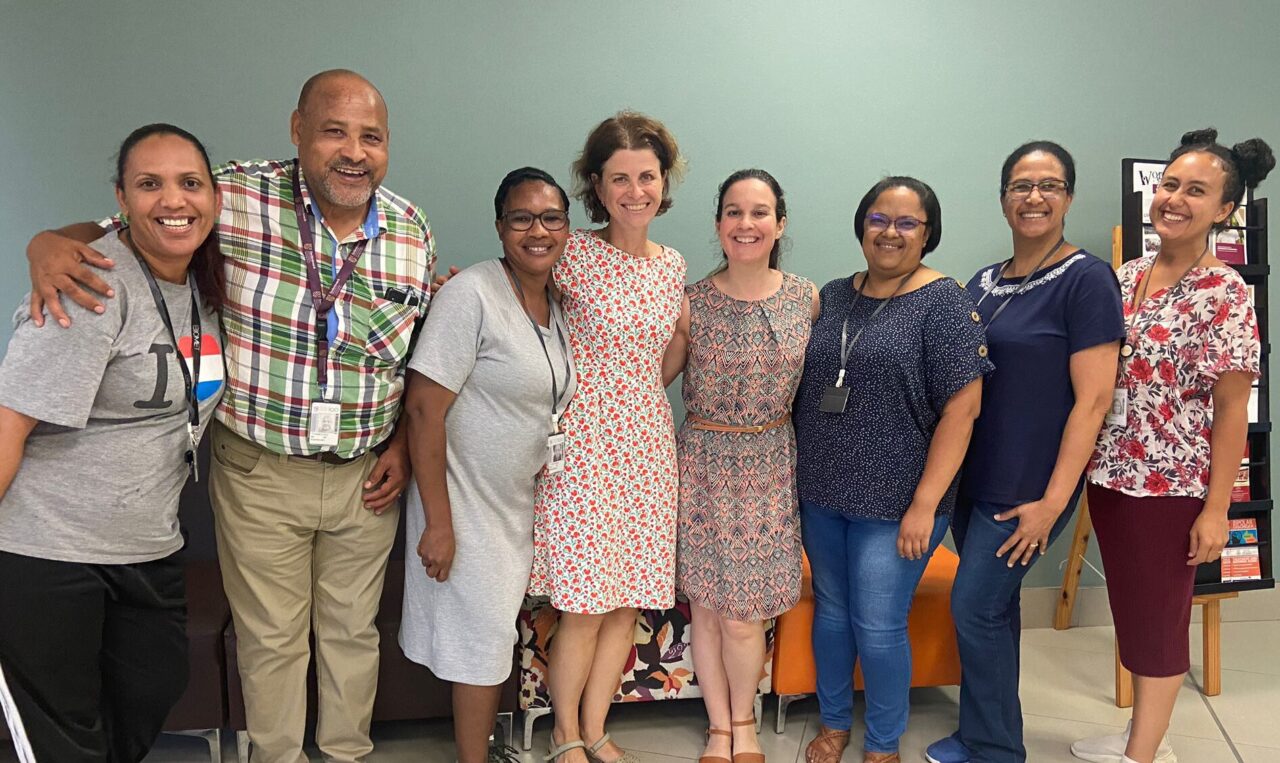 members of the global tuberculosis research team at bmc standing in a line smiling at the camera