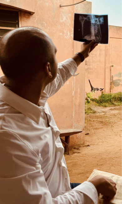 Pranay Sinha, in the field, views an x-ray of a patient's lungs. Photo by Madolyn Dauphinais.