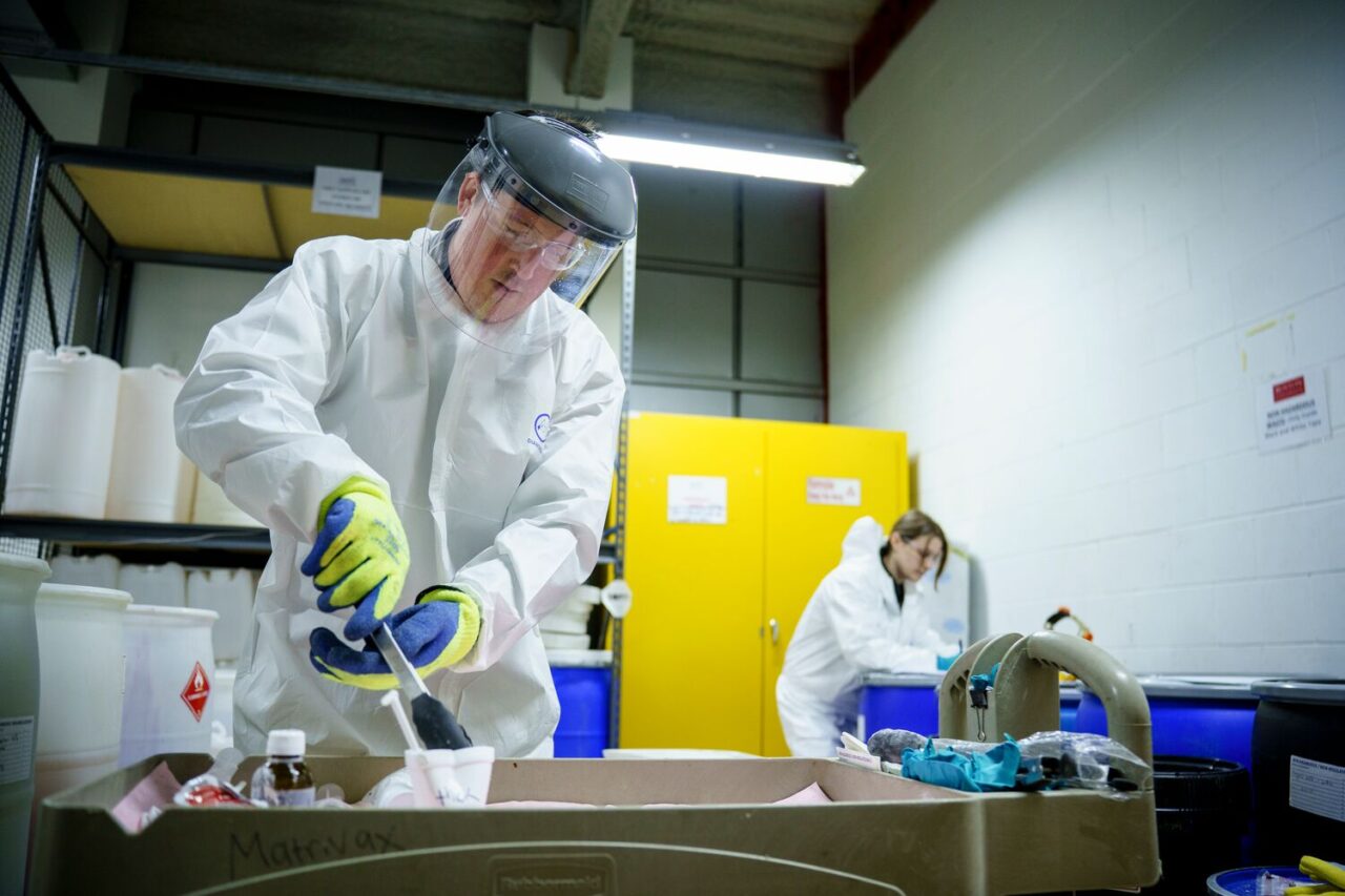 A Takeda worker poses for a photo illustrating medical waste disposal. Reducing waste and supply chain emissions helps to reduce healthcare’s climate footprint and support patient health. 
