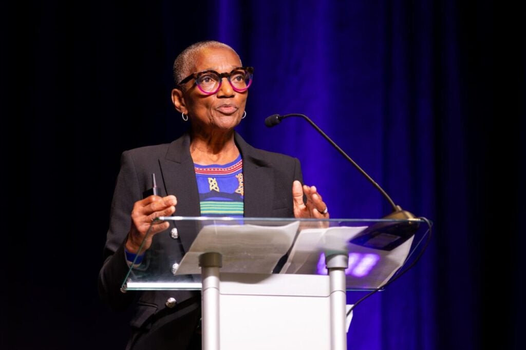dr. thea james standing behind a white podium